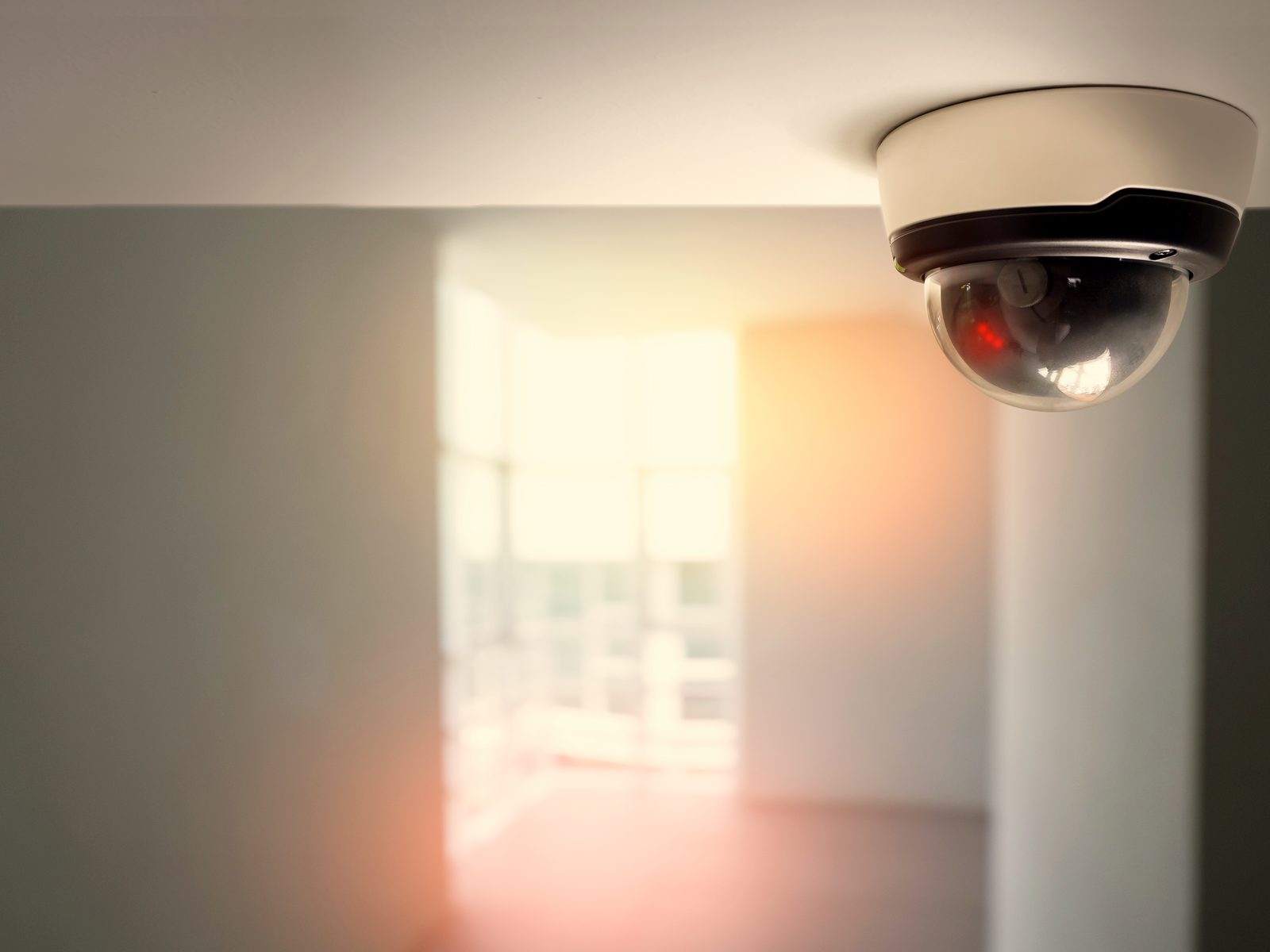 Bewakingscamera aan het plafond van een lichte gang